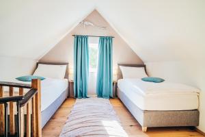 杜伦斯坦Wachau-Living的阁楼卧室设有两张床,配有蓝色窗帘