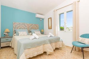 圣托马斯Villa Noelia的蓝色卧室,配有床和椅子