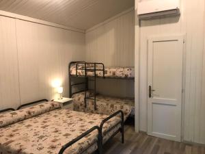 Candia Canavese安萨勒斯世界度假酒店的带两张双层床和一扇门的房间
