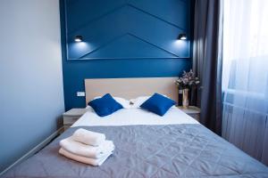 阿斯塔纳ARENA Hotel的蓝色卧室,配有带毛巾的床
