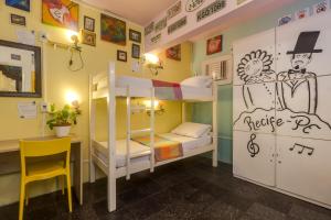 累西腓Fit Hostel的客房设有双层床、书桌和椅子。