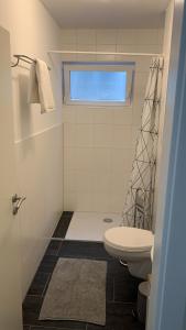 FrensdorfSüßes Zimmer im Souterrain的白色的浴室设有卫生间和窗户。