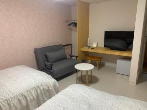 佐渡市Sado - Hotel - Vacation STAY 82476的一间卧室配有一张床、一张桌子和一把椅子