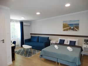 米耶伦科Willa Morska的一间卧室配有蓝色的床和蓝色的沙发