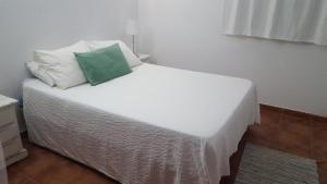 扎霍拉Casa Baro的一张白色的床,上面有绿色枕头