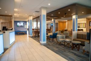 RichburgHoliday Inn Express & Suites Richburg, an IHG Hotel的医院的大厅,配有桌椅