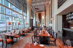 新加坡The Fullerton Bay Hotel Singapore的餐厅设有桌椅和窗户。