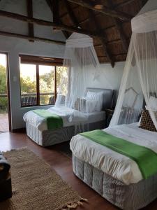 帕特森Camp Acacia的一间卧室配有两张带蚊帐的床