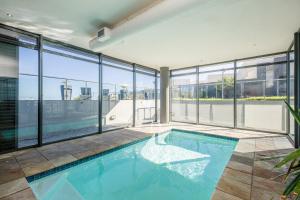 布鲁堡史特兰无限自炊式公寓的一座带玻璃窗的建筑中的游泳池