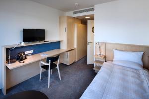 Holice欧文容克酒店的酒店客房配有一张床和一张书桌及一台电视