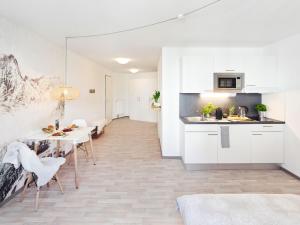 莱因费尔登-埃希特尔丁根NEU☆Business Apartment☆Messe/Airport☆Tiefgarage的厨房以及带白色橱柜和桌子的用餐室。