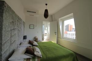 安特卫普安特卫普心灵公寓式酒店的一间卧室设有一张带窗户的绿色床