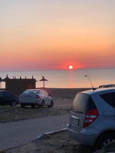 旧瓦马Vila Sunrise的两辆汽车在海滩上停车,日落