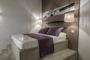 特拉尼BORGOBELTRANI的一间卧室配有一张带紫色枕头的床