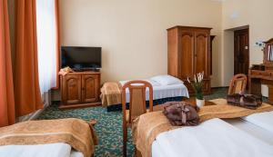 布达佩斯City Hotel UNIO superior的酒店客房设有三张床和电视。