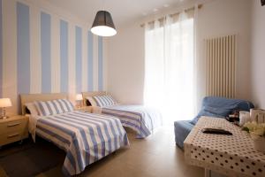 斯培西亚Affittacamere e appartamenti - Rent rooms and Apartments Le Camere Nel Corso - ADULTS ONLY的一间带两张床和一张沙发的客厅