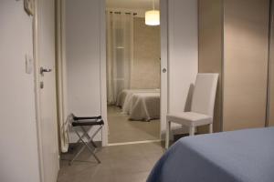 斯培西亚Affittacamere e appartamenti - Rent rooms and Apartments Le Camere Nel Corso - ADULTS ONLY的一间卧室,带一张床和一把椅子的房间