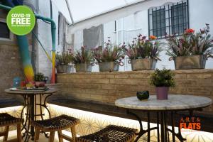 瓦伦西亚Art&Flats Hostel的两把桌子和椅子,位于种有植物的庭院