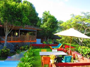 甘地达萨曼吉斯花园迪维度假酒店的庭院配有桌椅和遮阳伞。