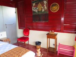 甘地达萨曼吉斯花园迪维度假酒店的一间卧室设有一张床和红色的墙壁