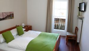 菲耶嘉斯托艾尔伯格克利乌崔酒店的一间卧室配有一张带绿色枕头的床和一扇窗户