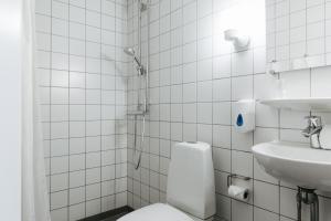 哥本哈根尼波城市酒店的白色瓷砖浴室设有卫生间和水槽