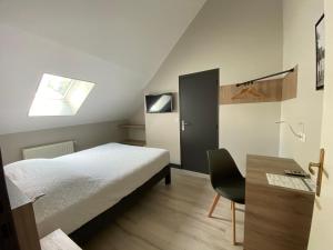 肖蒙昂韦克桑LOGIS - Hôtel Saint Nicolas的一间卧室配有一张床、一张书桌和一个窗户。