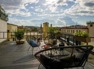 布拉格Rooftop Planet Prague Hotel的市景阳台配有椅子