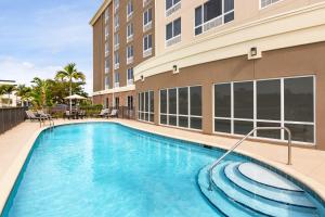 迈尔斯堡Holiday Inn Express Hotel & Suites Fort Myers East - The Forum, an IHG Hotel的大楼前的游泳池