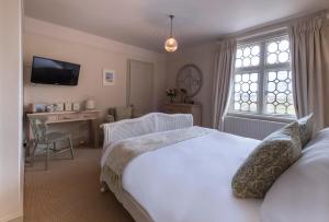 邓尼奇邓尼奇船舶旅馆的一间卧室配有一张床、一张书桌和一台电视