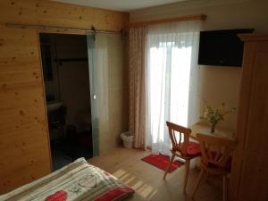 滨湖伦茨Bio Bauernhof Moas的一间卧室配有一张床、一张桌子和一个窗户。