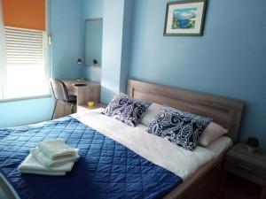 波德戈里察Apartment Temple的蓝色卧室,配有带毛巾的床