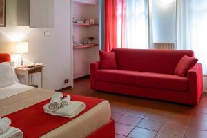 皮内罗洛费劳德公寓的酒店客房配有红色的沙发和床。