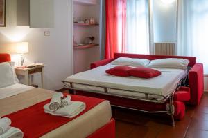 皮内罗洛费劳德公寓的酒店客房 - 带两张带红色枕头的床