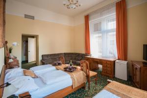 布达佩斯City Hotel UNIO superior的一间卧室配有两张床、一张桌子和一张沙发
