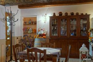 斯波莱托橄榄花农家乐的一间带桌子和橱柜的用餐室