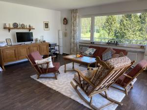 申瓦尔德Haus Gutach的客厅配有沙发、椅子和桌子