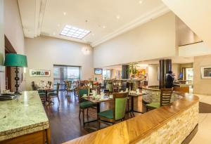 哈博罗内Town Lodge Gaborone的一间带桌椅的餐厅和一间酒吧