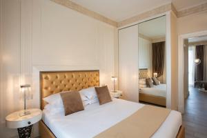 米兰米兰大教堂套房旅馆的一间卧室配有一张大床和镜子