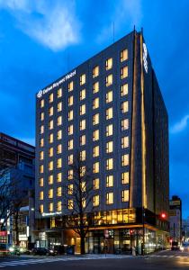 仙台Daiwa Roynet Hotel Sendai Ichibancho PREMIER的一座高大的黑色建筑,灯火通明