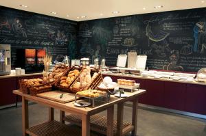 维也纳pentahotel Vienna的面包店,有一张桌子,上面放满了面包和糕点