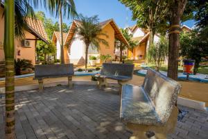 IguaraçuOdy Park Resort Hotel的两把椅子和一张长凳位于房子前面