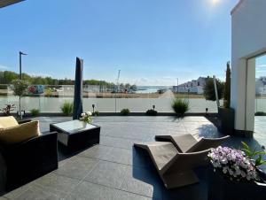 佩讷明德Exklusive Ferienwohnung mit Blick auf den Yachthafen的天井配有两张沙发、一张桌子和鲜花