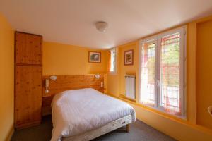 拉克河畔尚邦贝尔维尤酒店的卧室拥有黄色的墙壁,设有一张床和窗户。