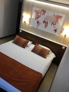 圣克莱芒德里维耶尔蒙彼利埃北欧洲医学公园酒店的一间卧室配有一张带两个枕头的床和一张地图