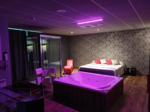 奥维多阿贝多乐斯汽车旅馆的紫色客房 - 带一张床和一个浴缸