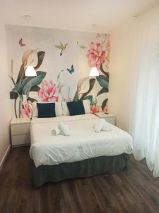 穆特里库Rin Rooms的卧室配有一张墙上鲜花的大床