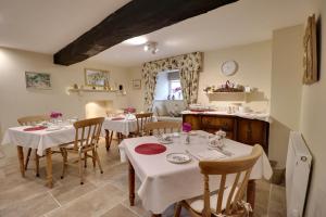 邓斯特Millstream Cottage B & B的用餐室配有带白色桌布的桌子