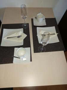 埃森Single-Apartment Essen的一张桌子,上面放着两个白板和一个葡萄酒杯