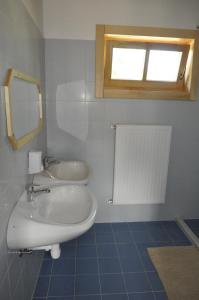 格拉克斯兹Bak Vendéglő faházak的一间带水槽和镜子的浴室以及窗户。